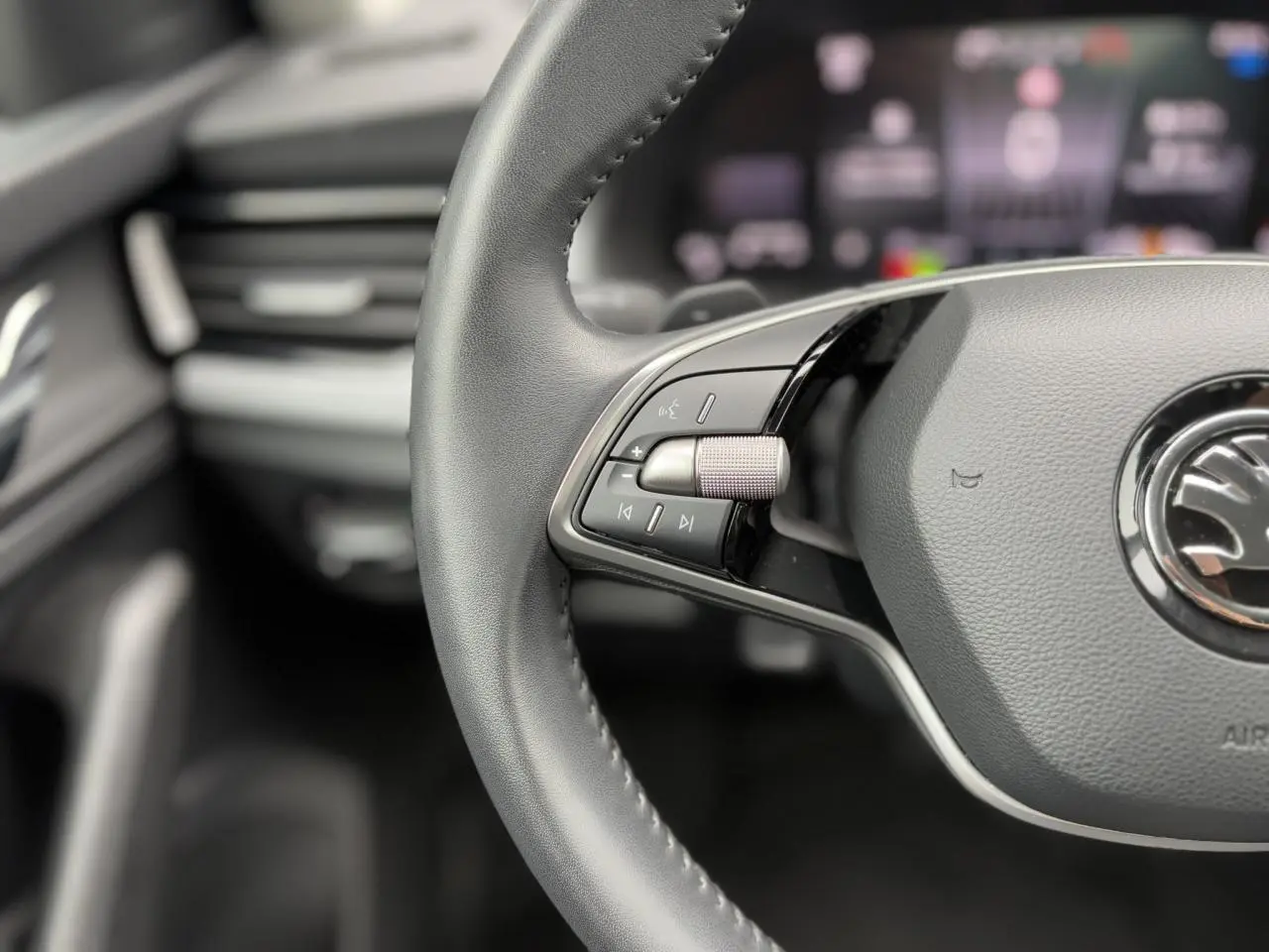 Gros plan sur le volant cuir multifonctions de la Skoda Scala 2024, mettant en valeur les commandes audio à gauche.