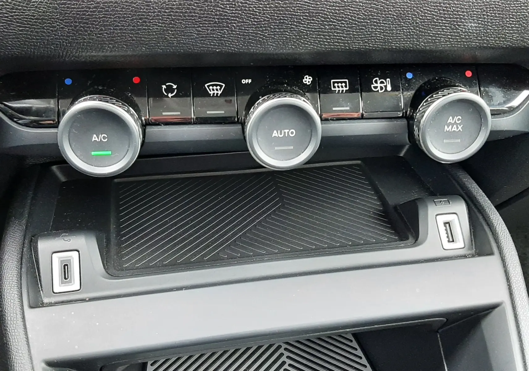 Détail de la console centrale de la Citroën C4 Hybrid 136, montrant les commandes de climatisation et ports USB.