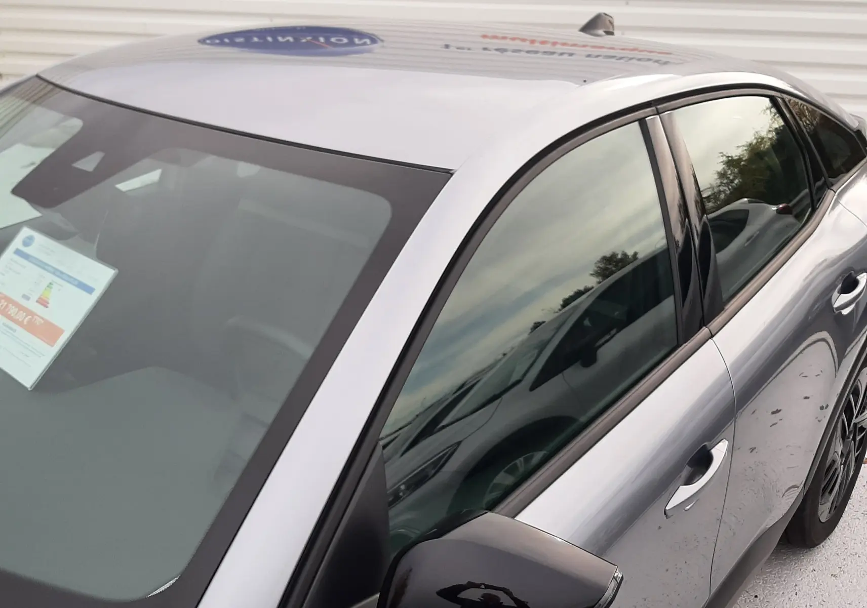 Vue 3/4 avant droit de la Citroën C4 Hybrid 136 gris acier avec rétroviseur noir brillant et vitres teintées.