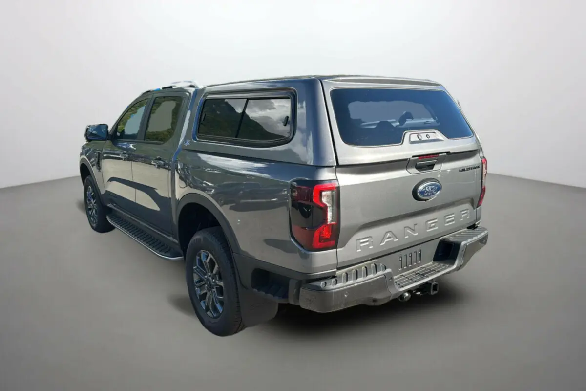 Vue 3/4 arrière droite du Ford Ranger Wildtrak gris carbone avec hard-top et jantes foncées, modèle 2025 diesel.