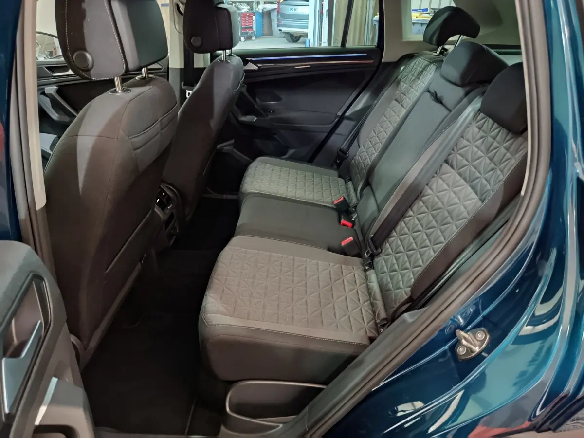 Vue côté droit de l'intérieur arrière du Volkswagen Tiguan bleu 2022 avec sièges tissu à motif géométrique.