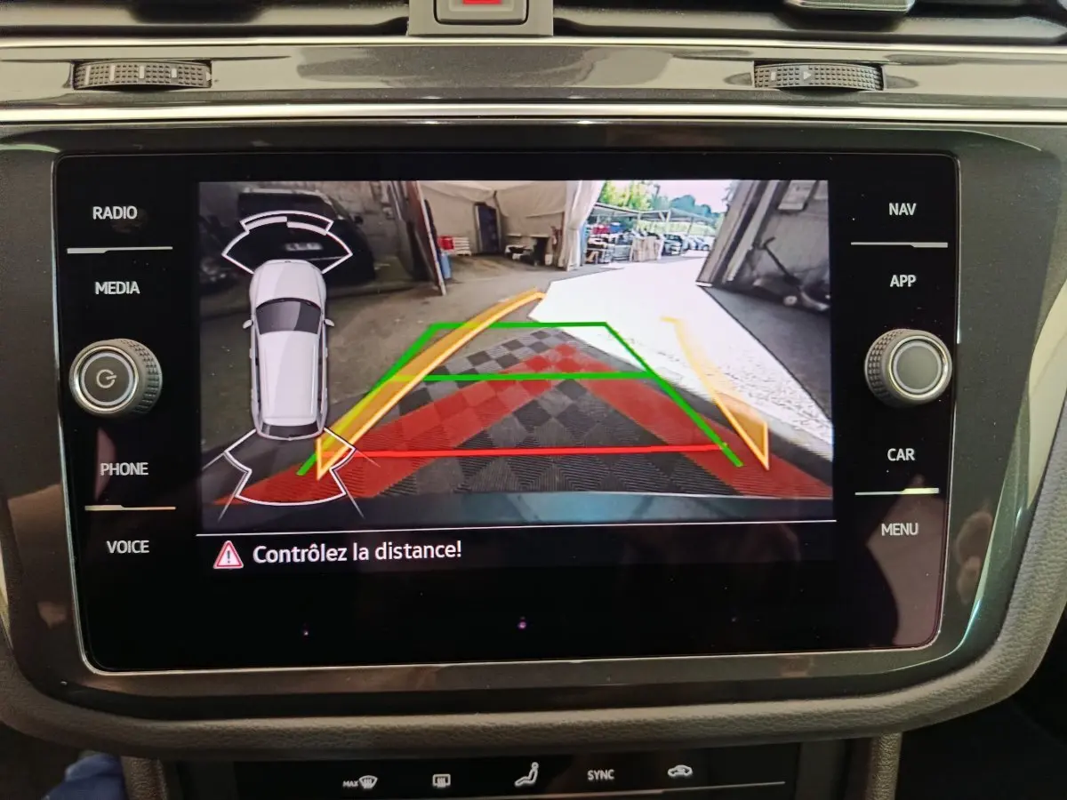 Écran tactile central du Volkswagen Tiguan bleu 2022 montrant la caméra de recul avec guidage de trajectoire coloré.