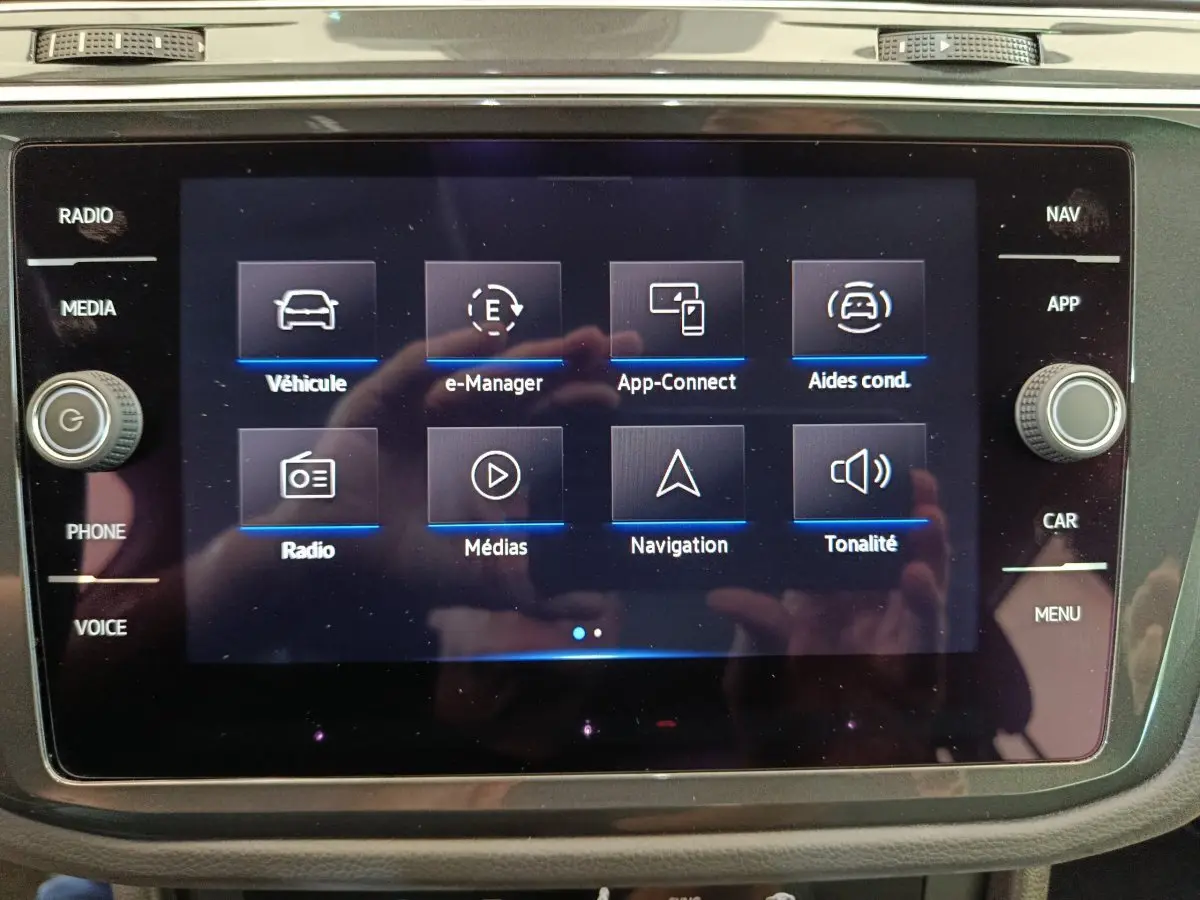 Écran tactile central du Volkswagen Tiguan hybride rechargeable 2022 affichant les menus de navigation et médias.