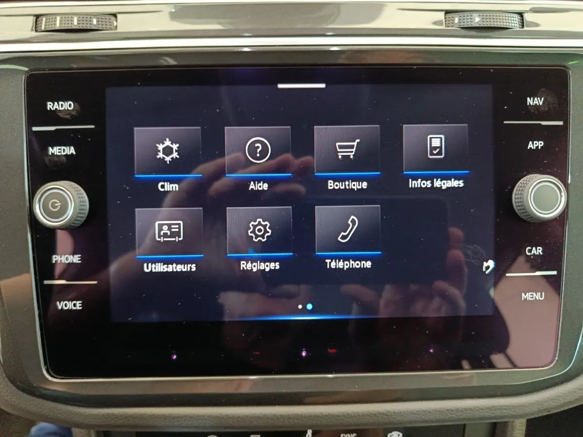 Écran tactile central du Volkswagen Tiguan 1.4 eHybrid 2022 affichant le menu principal avec options clim, aide et téléphone.