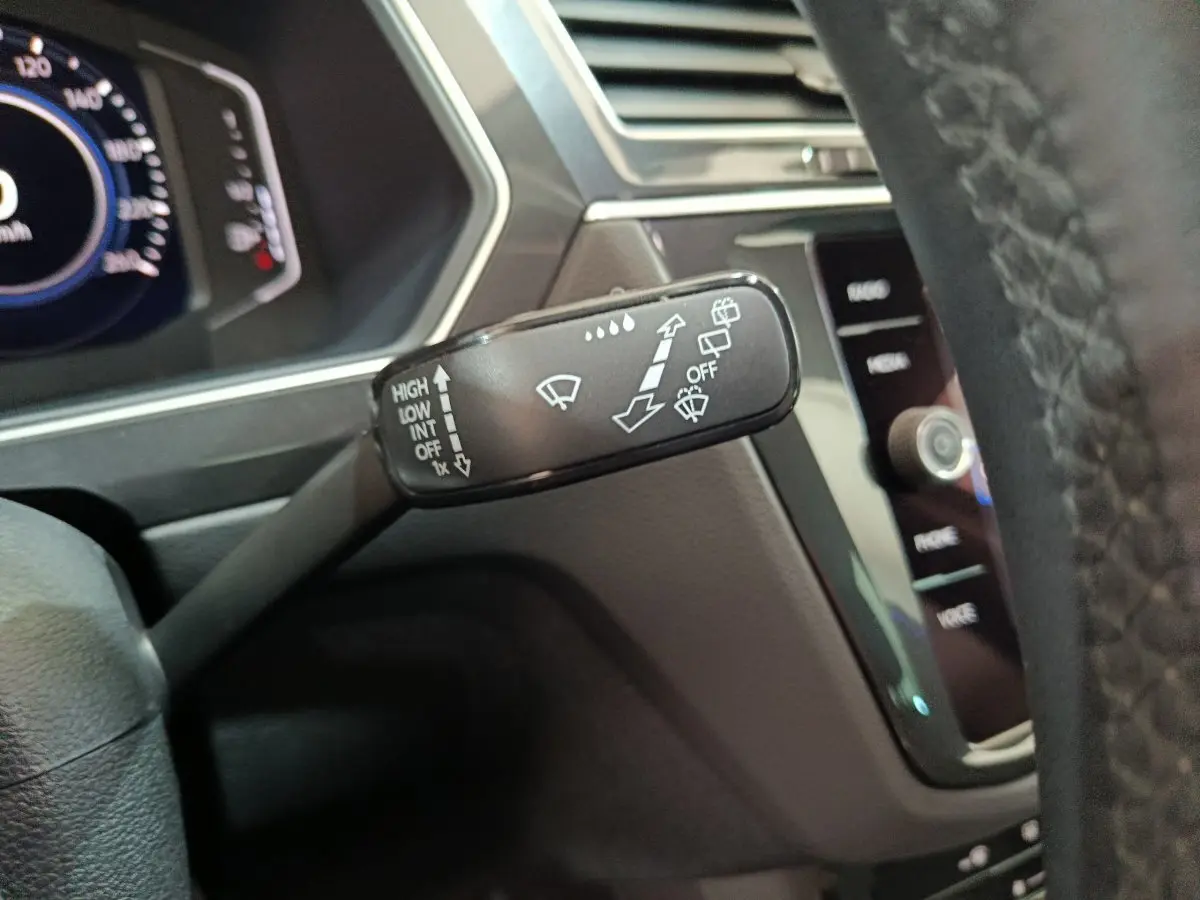 Gros plan sur la commande d’essuie-glace du Volkswagen Tiguan 1.4 eHybrid 2022, intérieur noir moderne.