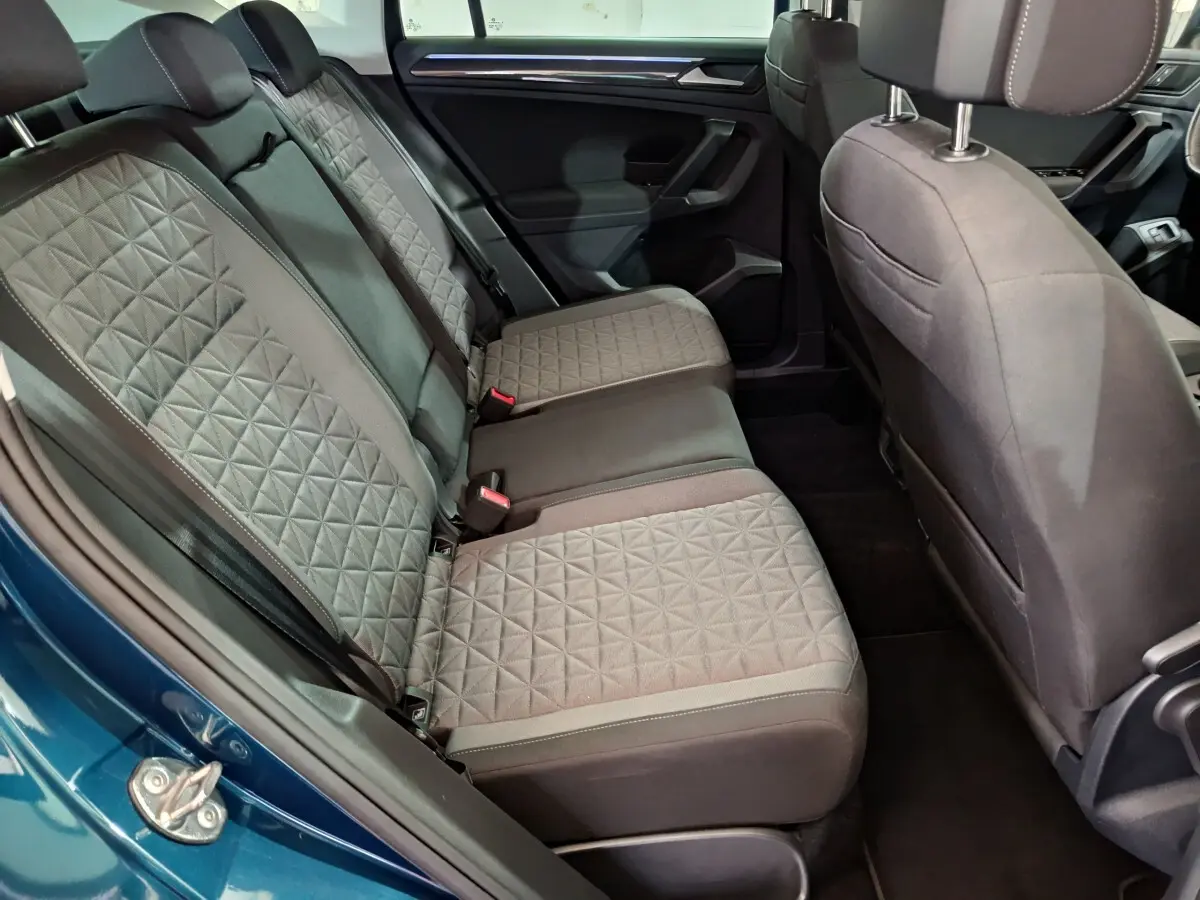Vue intérieure côté gauche sur la banquette arrière grise au tissu matelassé du Volkswagen Tiguan bleu 2022 hybride rechargeable.