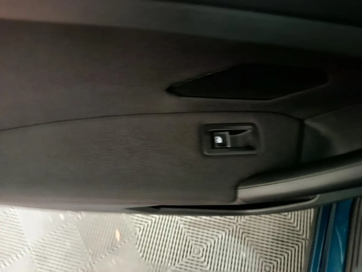 Détail de la poignée intérieure côté gauche d'une Volkswagen Tiguan hybride rechargeable bleu 2022.