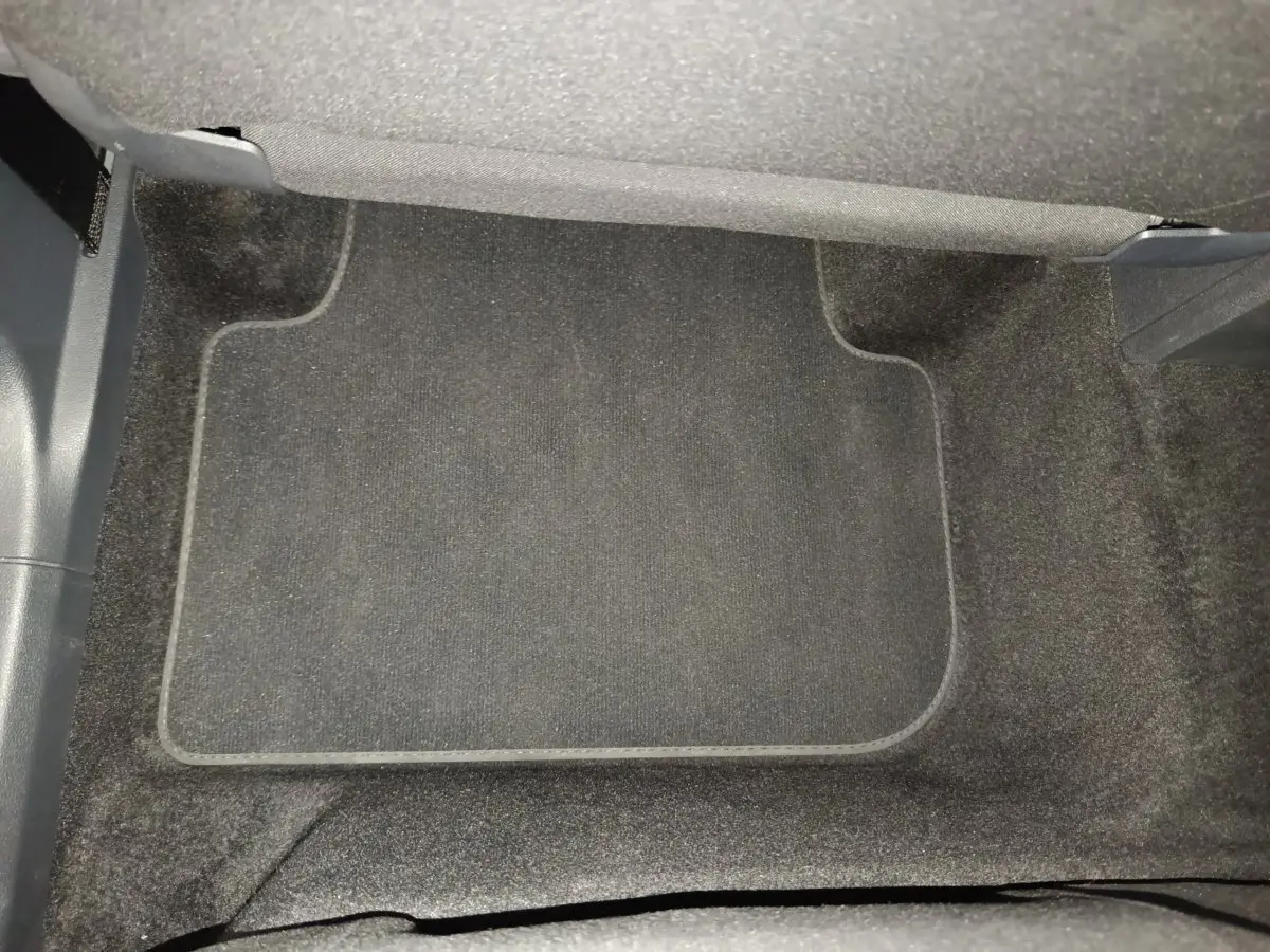 Tapis de sol noir dans l'habitacle avant du Volkswagen Tiguan 1.4 eHybrid 2022, vue plongeante.