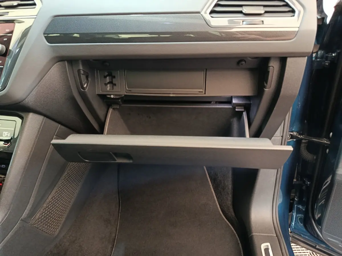 Gant de rangement ouvert côté passager dans l'habitacle bleu du Volkswagen Tiguan 2022 hybride rechargeable.