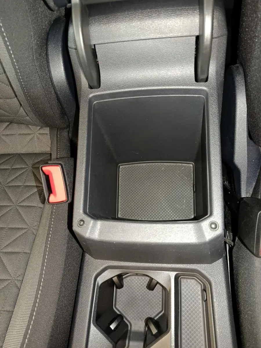 Vue plongeante sur le rangement central noir et porte-gobelets du Volkswagen Tiguan bleu hybride rechargeable 2022.