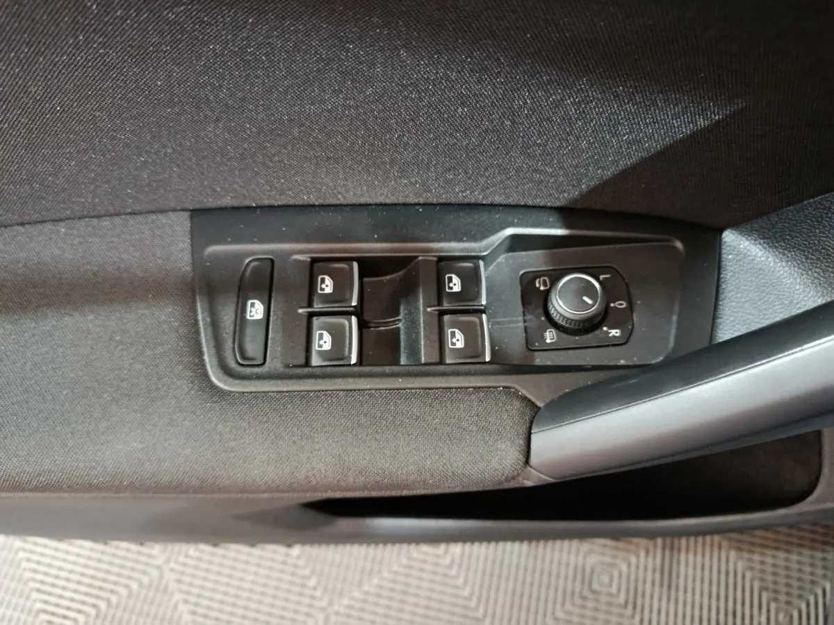 Panneau de commandes des vitres et rétroviseurs côté conducteur du Volkswagen Tiguan bleu 2022 hybride rechargeable.