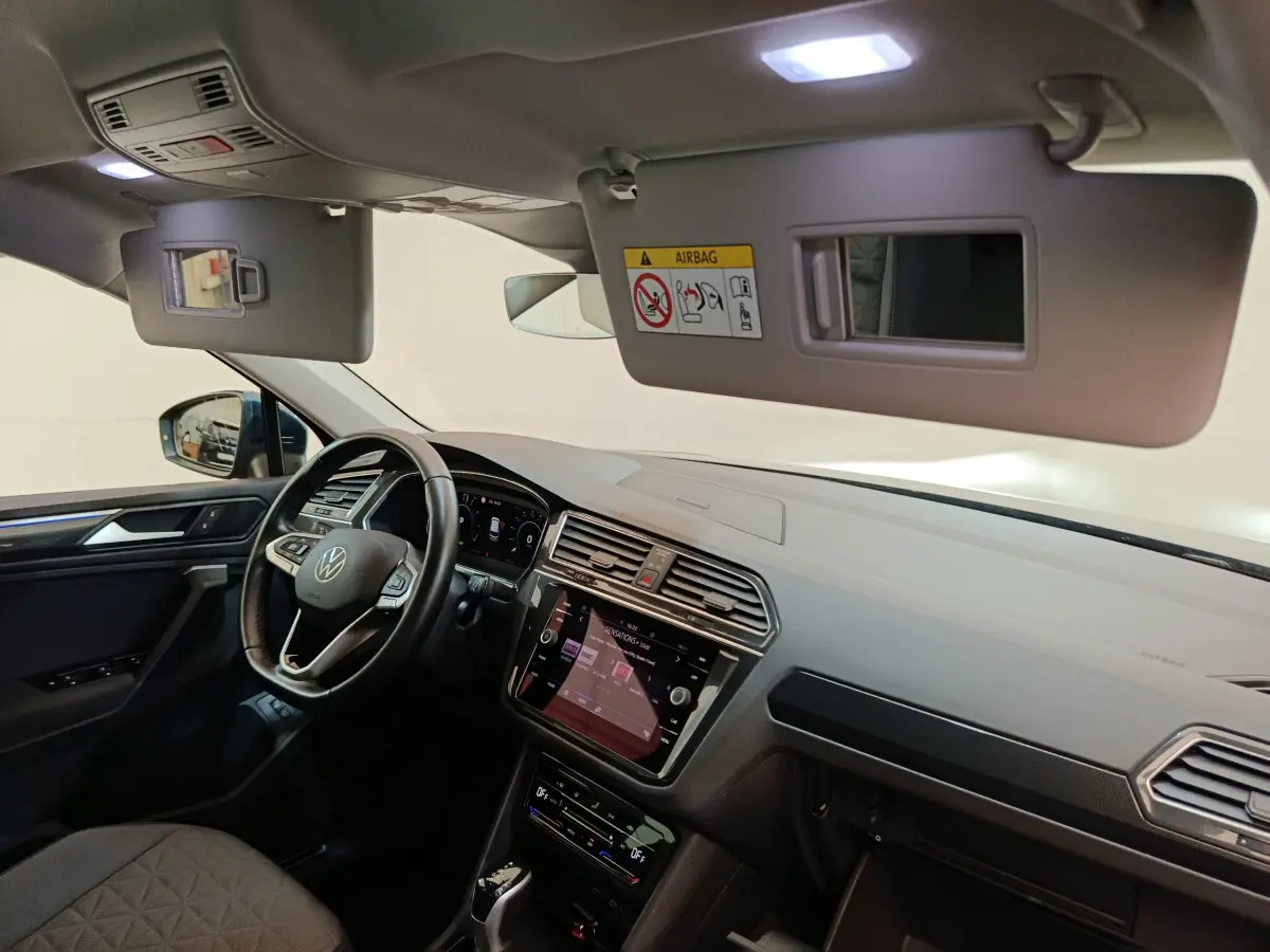Vue intérieure côté conducteur du Volkswagen Tiguan 2022, tableau de bord et écran tactile visibles.