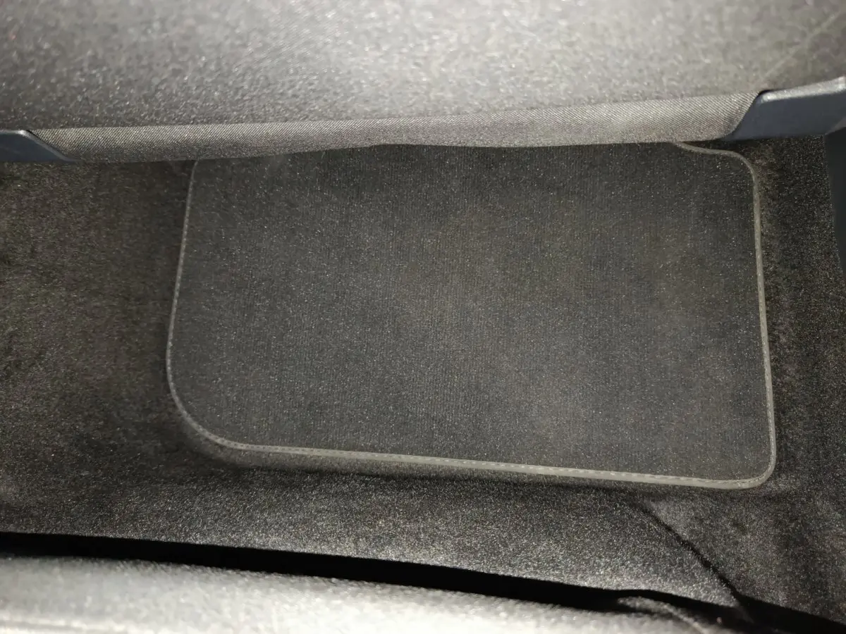 Tapis de sol noir côté passager avant du Volkswagen Tiguan 1.4 eHybrid 2022, intérieur sobre et propre.