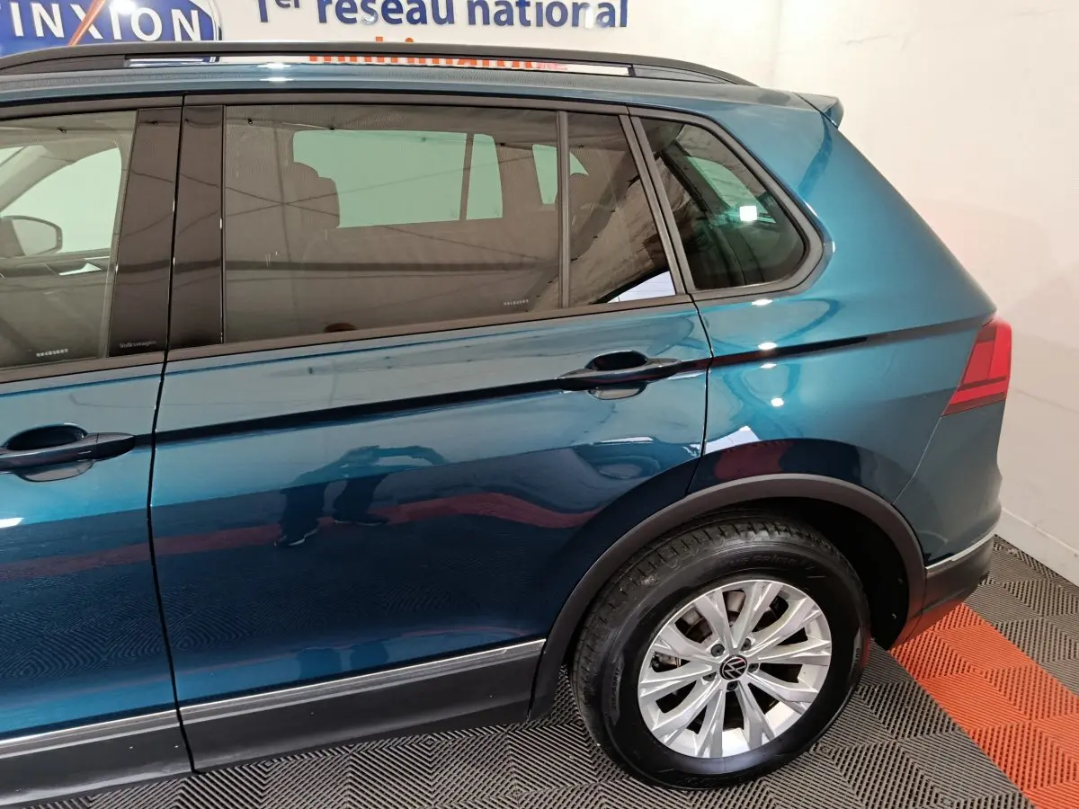 Vue côté droit arrière du Volkswagen Tiguan bleu 2022, mettant en valeur la jante alliage et la ligne de caisse.
