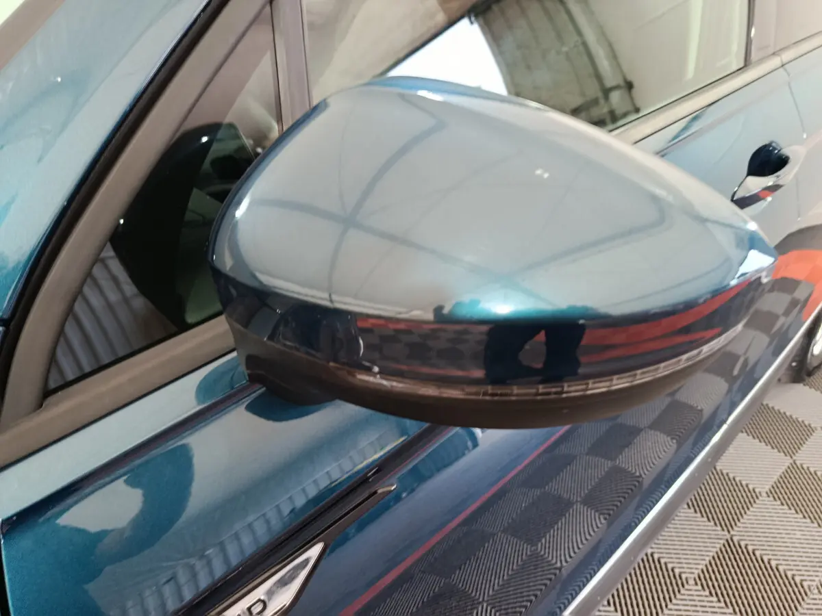 Rétroviseur côté gauche bleu métallisé du Volkswagen Tiguan 1.4 eHybrid 2022 avec clignotant intégré.