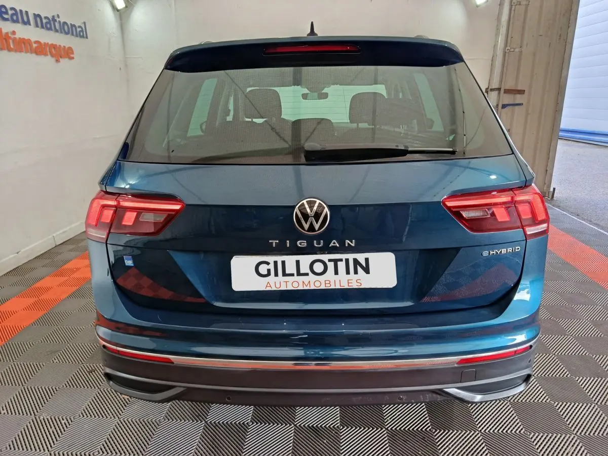 Vue arrière d'un Volkswagen Tiguan bleu hybride rechargeable 2022 avec logo et feux LED distinctifs.