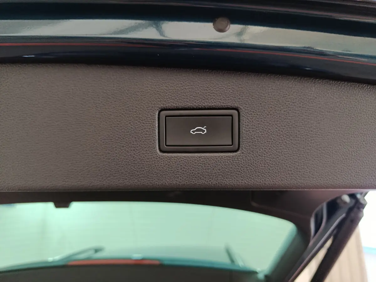 Bouton d'ouverture électrique du coffre sur la partie intérieure du hayon d'un Volkswagen Tiguan bleu 2022.