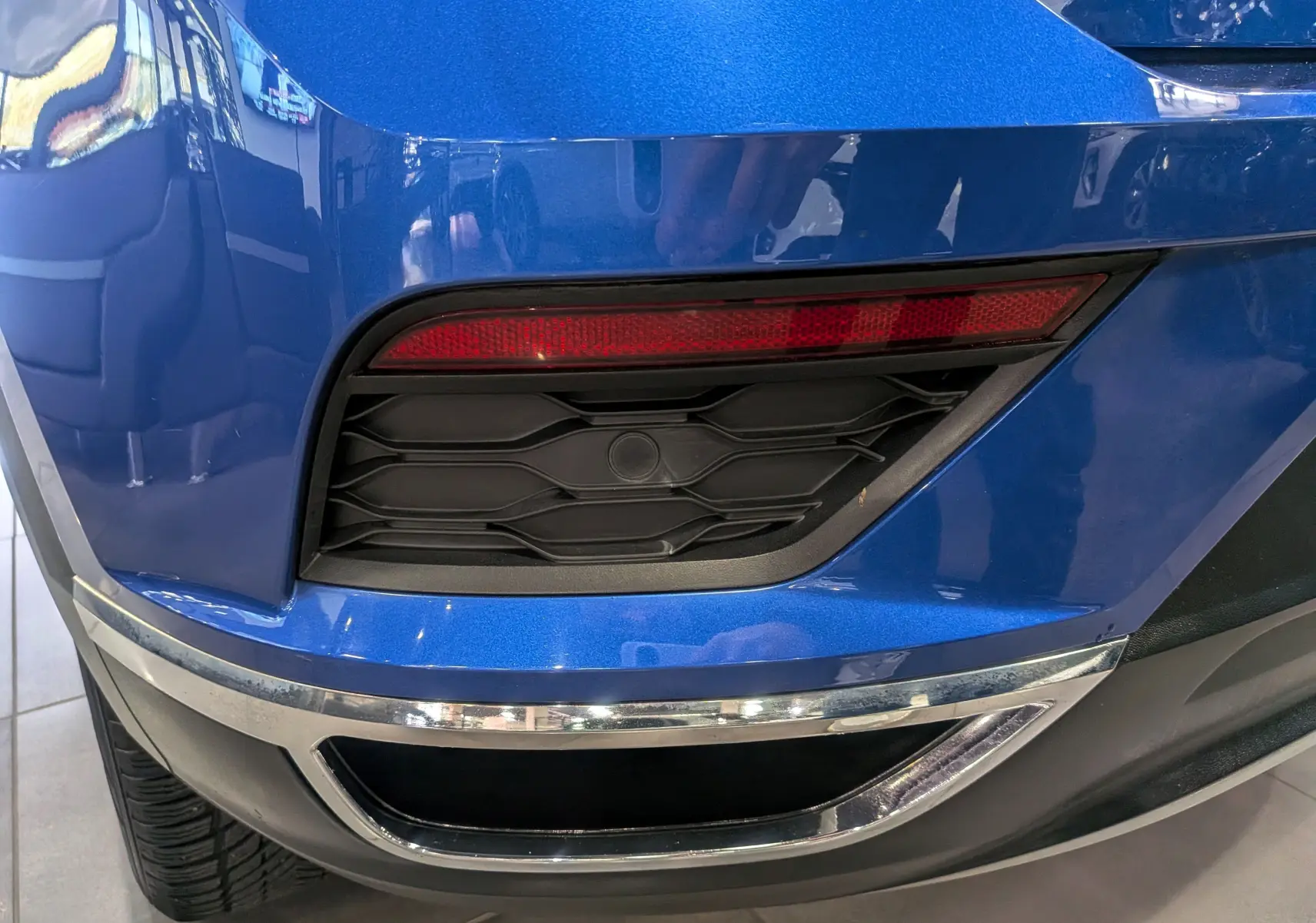 Gros plan sur le feu arrière droit et la partie inférieure bleue métallisée du pare-chocs arrière du Volkswagen T-Roc 2018.