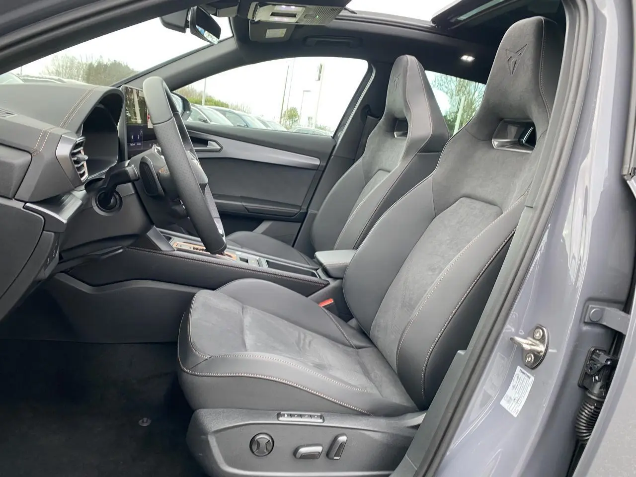 Vue intérieure côté conducteur du CUPRA Formentor gris Graphène 2025, sièges baquets suédine avec surpiqûres cuivrées.