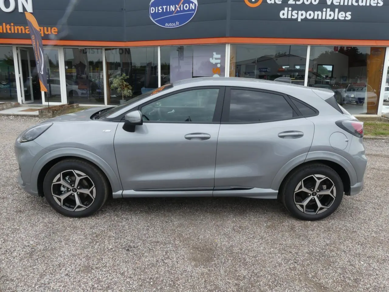 Profil côté gauche du Ford Puma 2025 gris métallisé avec jantes alliage et vitres arrière surteintées.