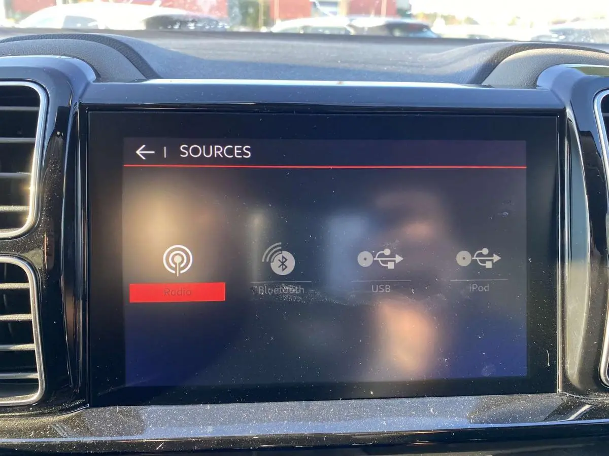 Écran tactile central du tableau de bord du Citroën C5 Aircross 2021 affichant les options sources audio.