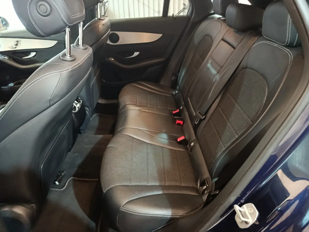 Vue côté droit de l'intérieur arrière du Mercedes GLC 300 E Business Line bleu, avec sièges en cuir noir et surpiqûres blanches.