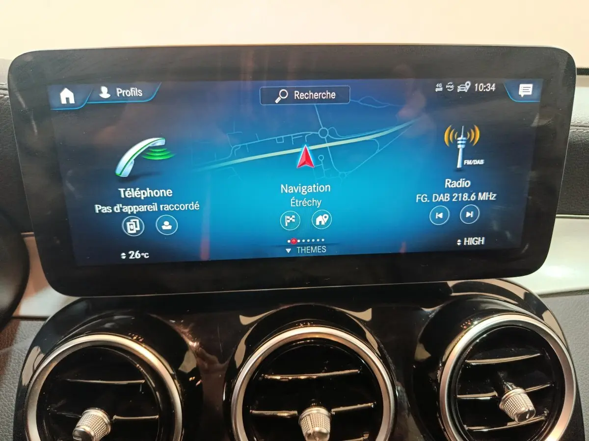 Écran tactile central affichant navigation, téléphone et radio dans le tableau de bord du Mercedes GLC 300 E bleu.