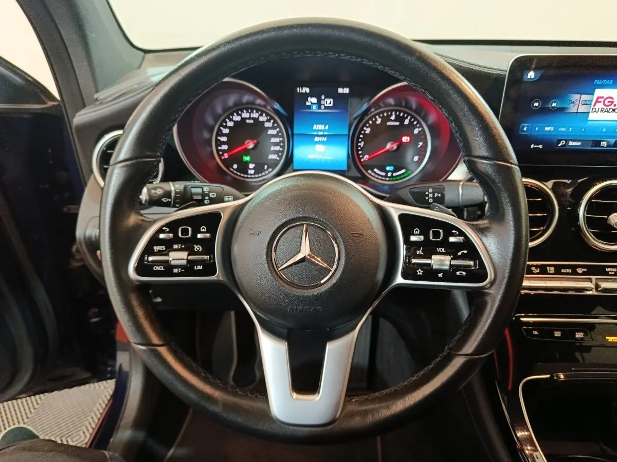 Vue rapprochée du volant cuir noir Mercedes GLC 300 E Business Line 2021 avec tableau de bord numérique et écran tactile.
