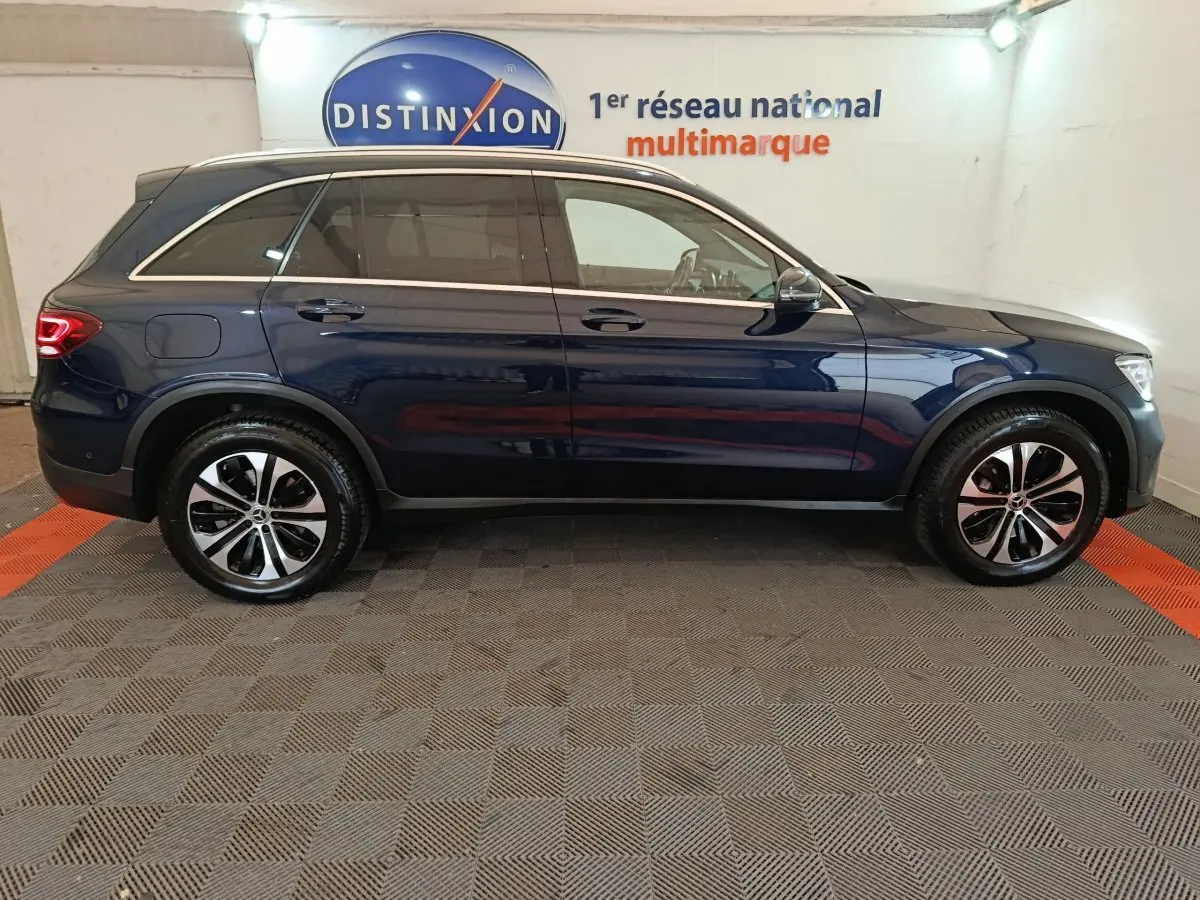 Profil côté droit d'un Mercedes GLC 300 E Business Line bleu hybride rechargeable, roues alliage et toit chromé visible.