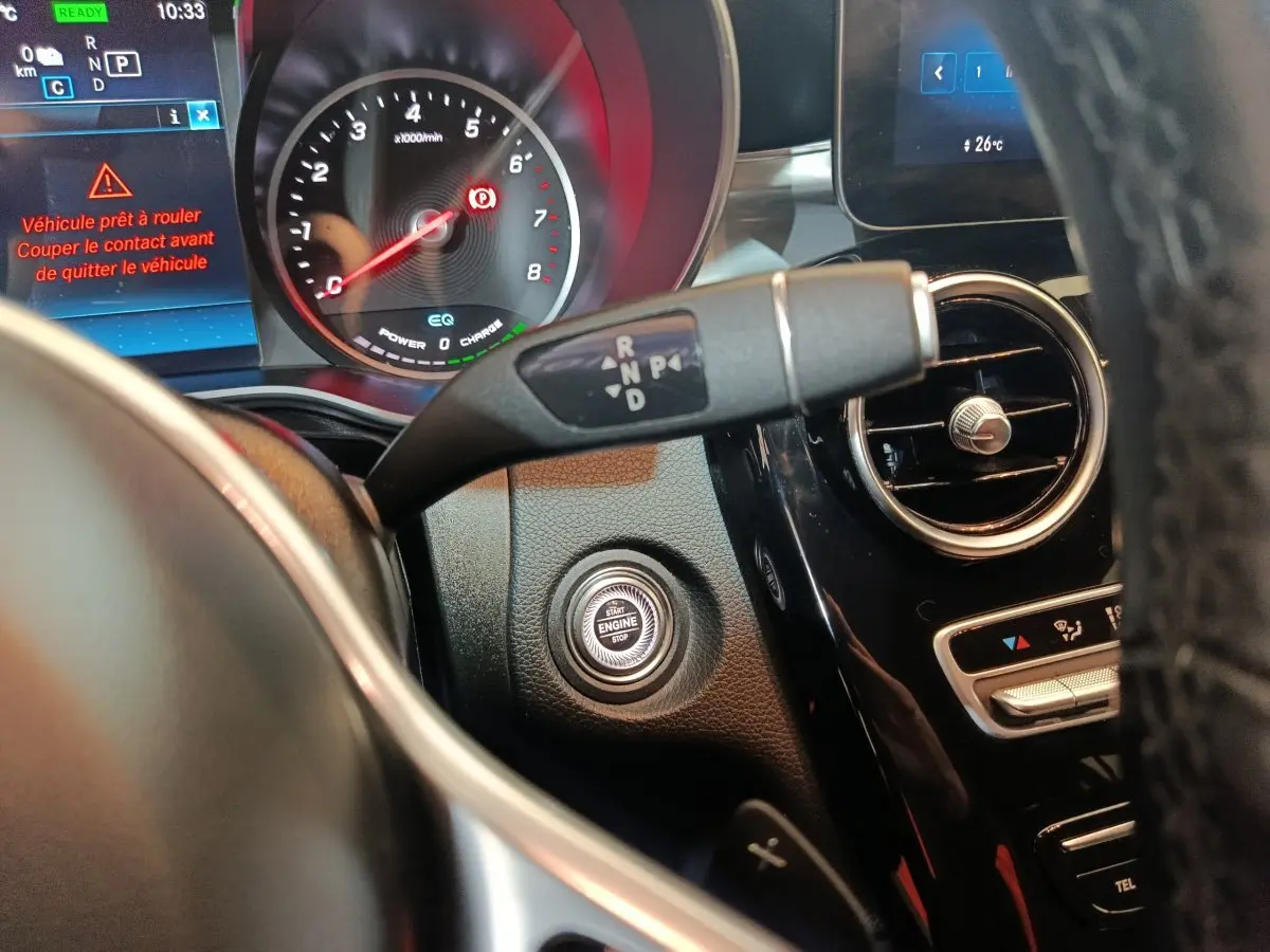 Gros plan intérieur sur le tableau de bord noir du Mercedes GLC 300 E hybride avec bouton démarrage et levier de vitesses.