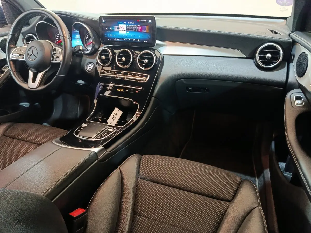 Intérieur noir du Mercedes GLC 300 E 2021 vu côté conducteur, avec tableau de bord et écran tactile central lumineux.
