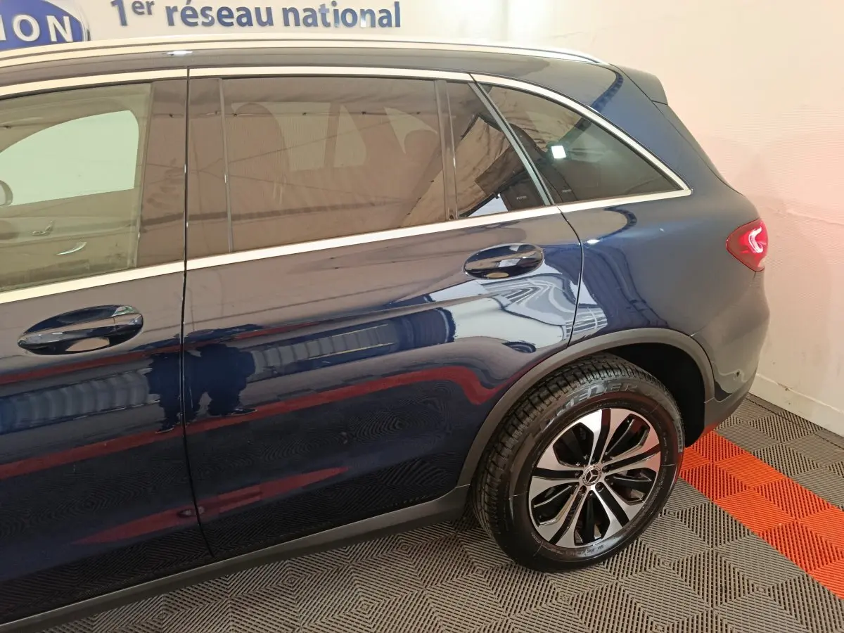 Vue côté droit arrière d'un Mercedes GLC 300 E Business Line bleu avec jante alliage et feux arrière LED.