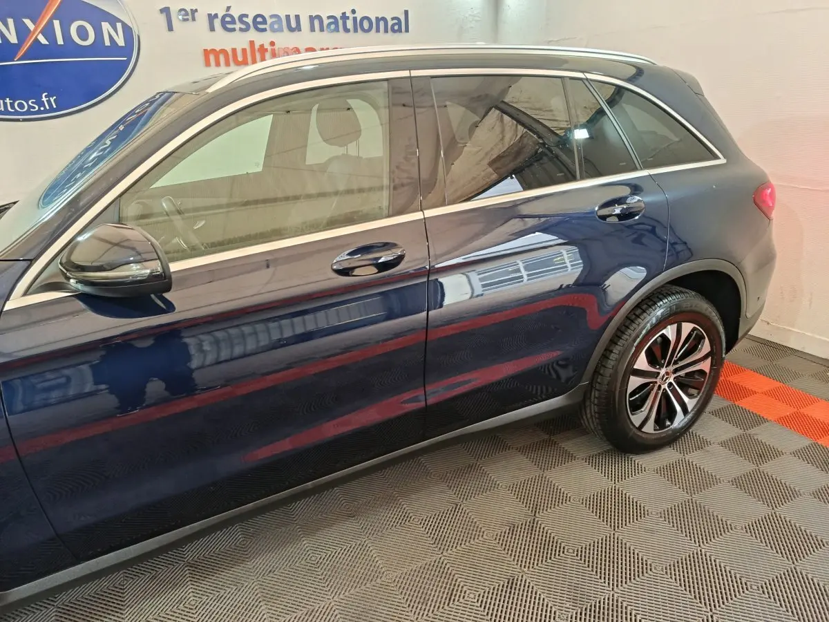 Vue latérale côté gauche d'un Mercedes GLC 300 E Business Line bleu avec jantes alliage et toit chromé.
