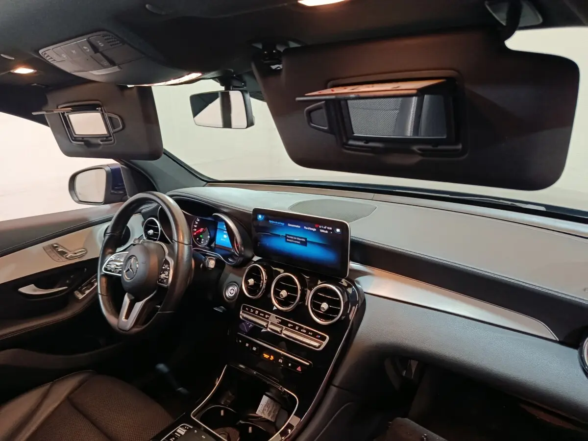 Intérieur avant du Mercedes GLC 300 E Business Line 2021, tableau de bord noir avec écran tactile central et volant cuir.
