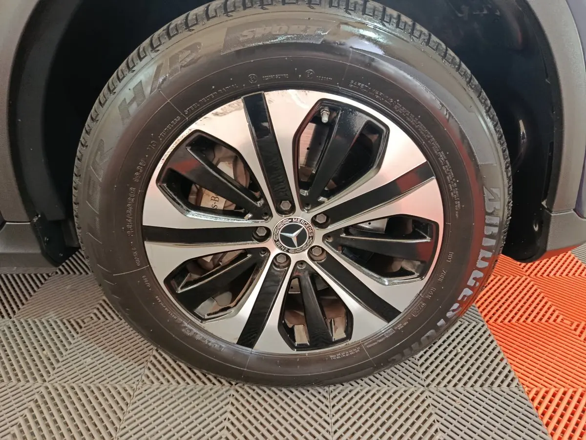 Gros plan sur la roue avant droite du Mercedes GLC bleu, jante alliage bicolore avec logo étoile centrale.