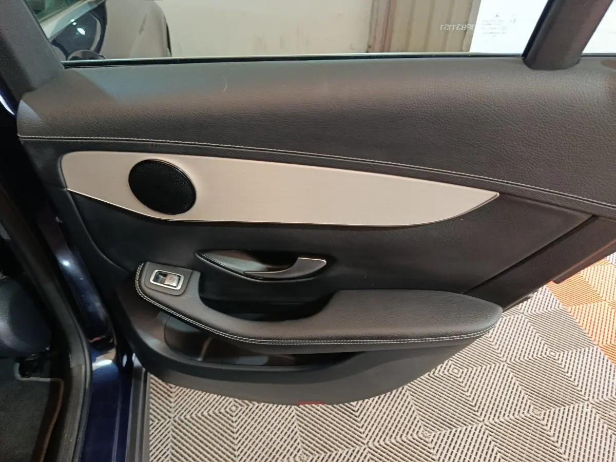 Gros plan sur la porte arrière gauche bleu foncé du Mercedes GLC 300 E avec garniture noire et insert aluminium.