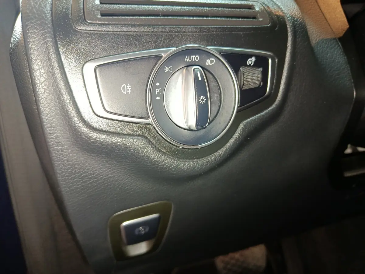 Gros plan sur le bouton de commande des phares dans l'habitacle noir du Mercedes GLC 300 E Business Line 2021.