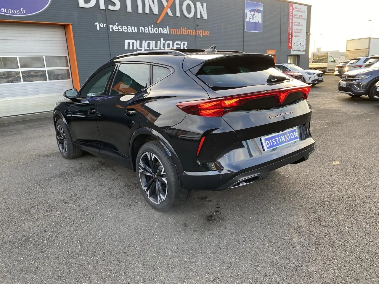 Vue 3/4 arrière droite d'un CUPRA Formentor noir Midnight avec jantes 18 pouces et feux arrière LED distinctifs.