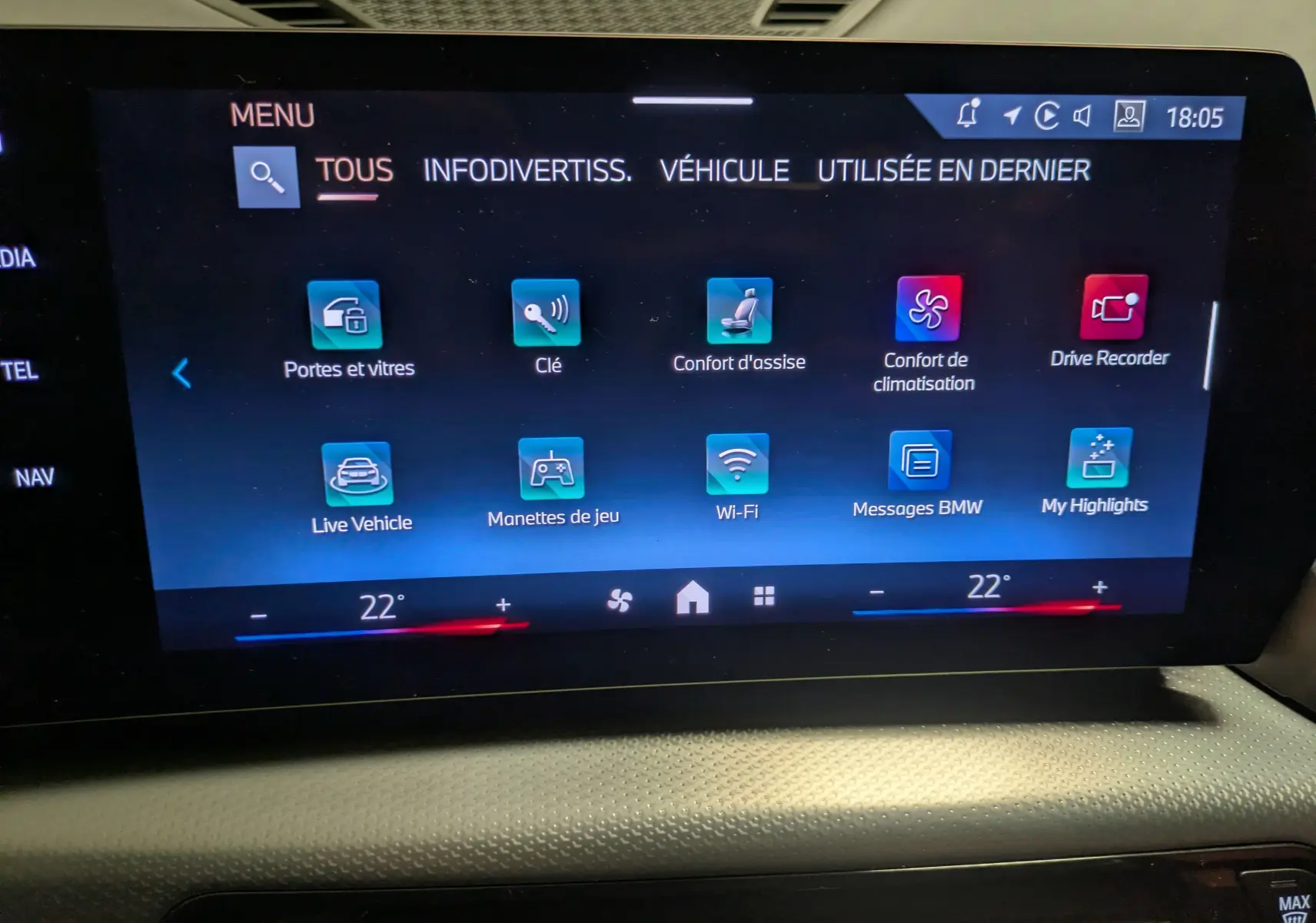 Écran tactile central du BMW X1 blanc 2025 affichant le menu des fonctions connectées et climatisation à 22°C.