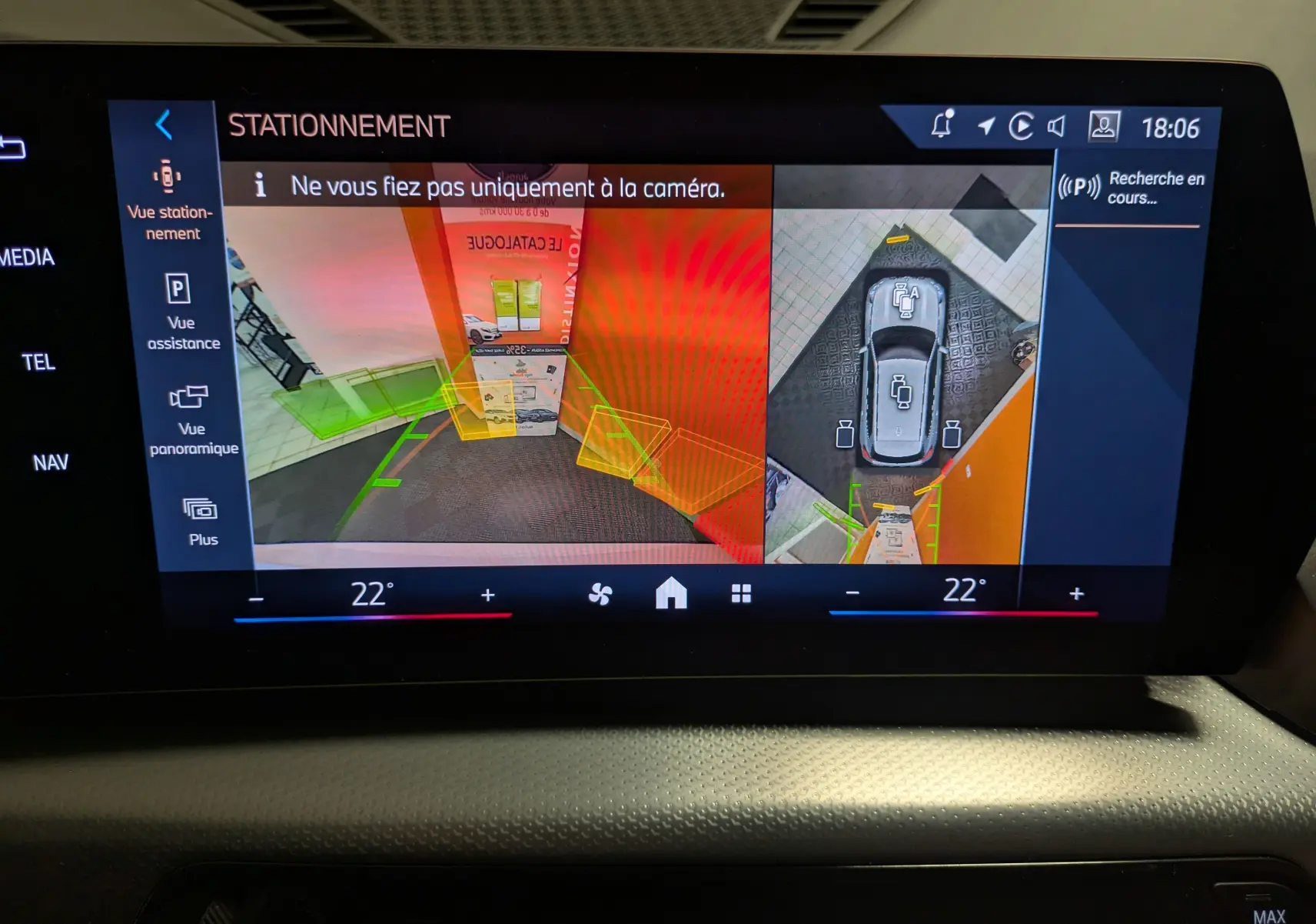 Vue écran caméra 360° du BMW X1 blanc en stationnement, affichant l'environnement autour du véhicule.