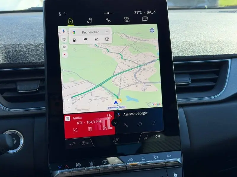 Écran central tactile du Renault Captur 2025 affichant la navigation Google Maps et la radio RTL sur fond rouge.
