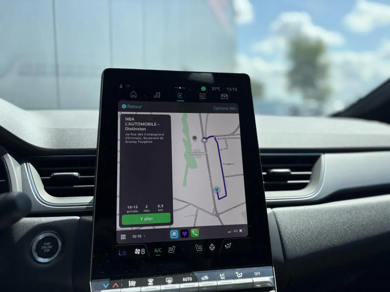 Vue rapprochée de l'écran tactile central du Renault Captur gris Cassiopée affichant la navigation GPS et commandes climatisation.