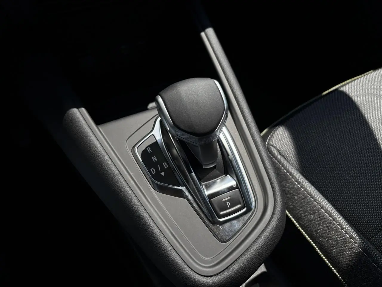 Le levier de vitesses automatique noir et chrome du Renault Captur gris Cassiopée, vue rapprochée de la console centrale.
