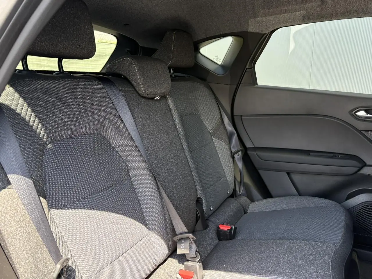 Vue côté droit de la banquette arrière grise du Renault Captur 2025 avec ceintures et appuie-têtes intégrés.