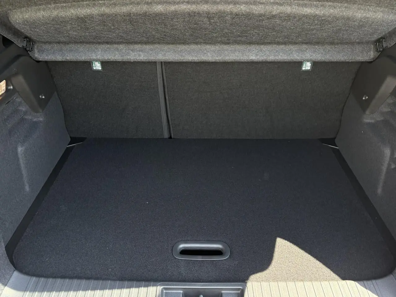 Coffre spacieux et propre du Renault Captur gris Cassiopée, vue intérieure avec plancher de coffre mobile relevé.