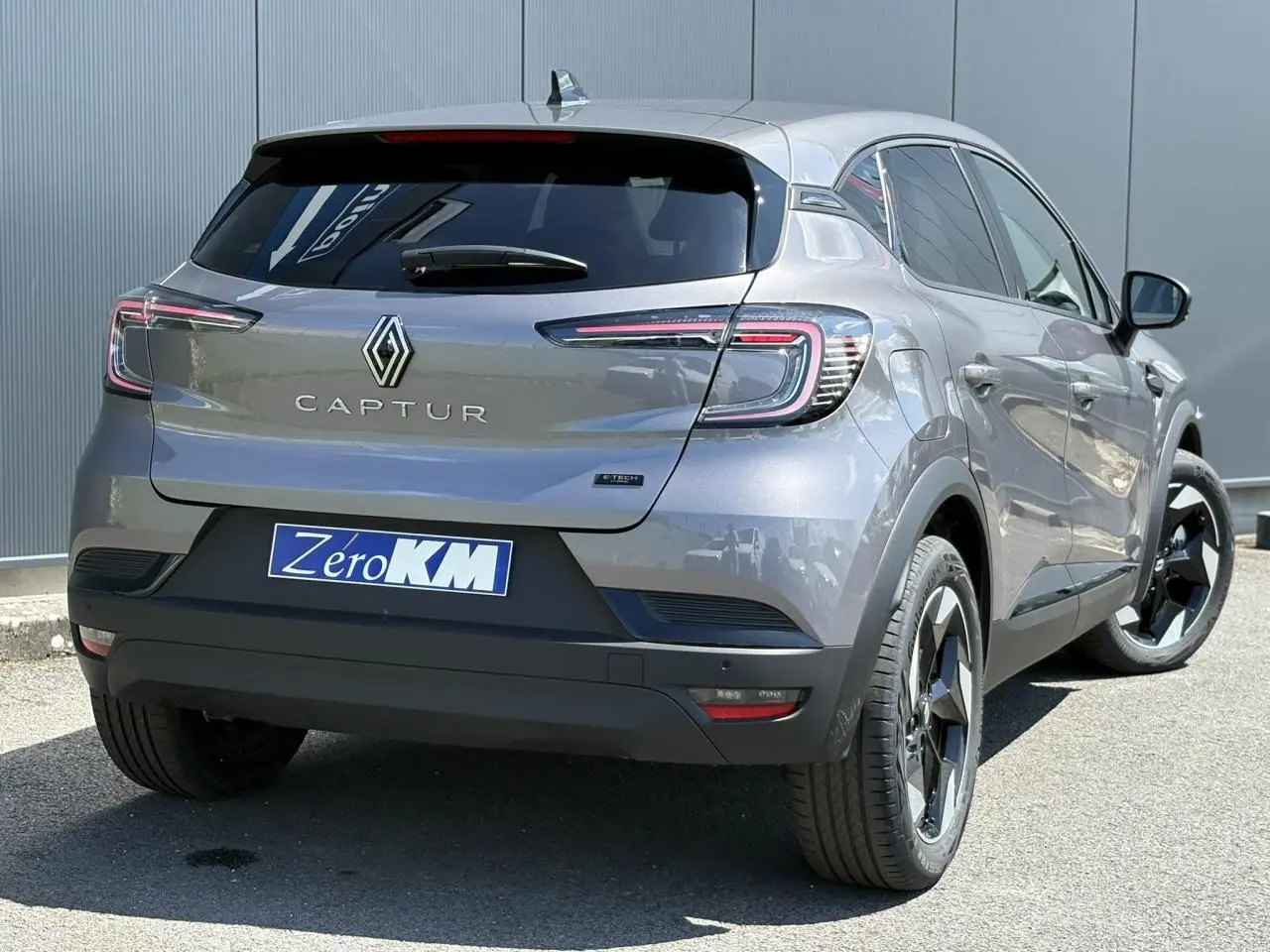 Vue 3/4 arrière droite d'un Renault Captur gris Cassiopée avec jantes aluminium 18 pouces et vitres surteintées.