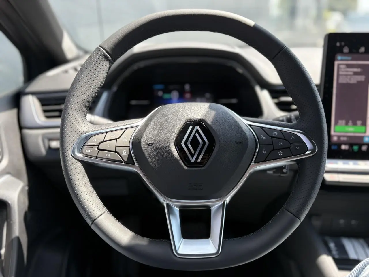 Volant cuir multifonctions de Renault Captur gris Cassiopée, vue frontale centrée sur les commandes intégrées.