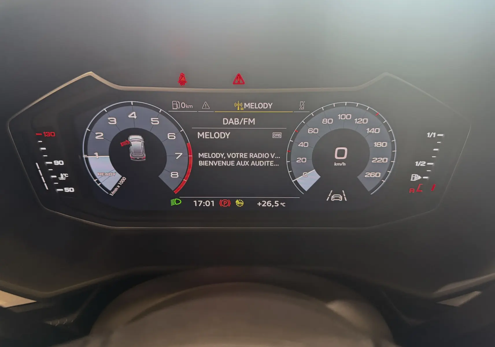 Tableau de bord numérique de l'Audi A1 2024 affichant la vitesse, régime moteur et radio DAB en veille.