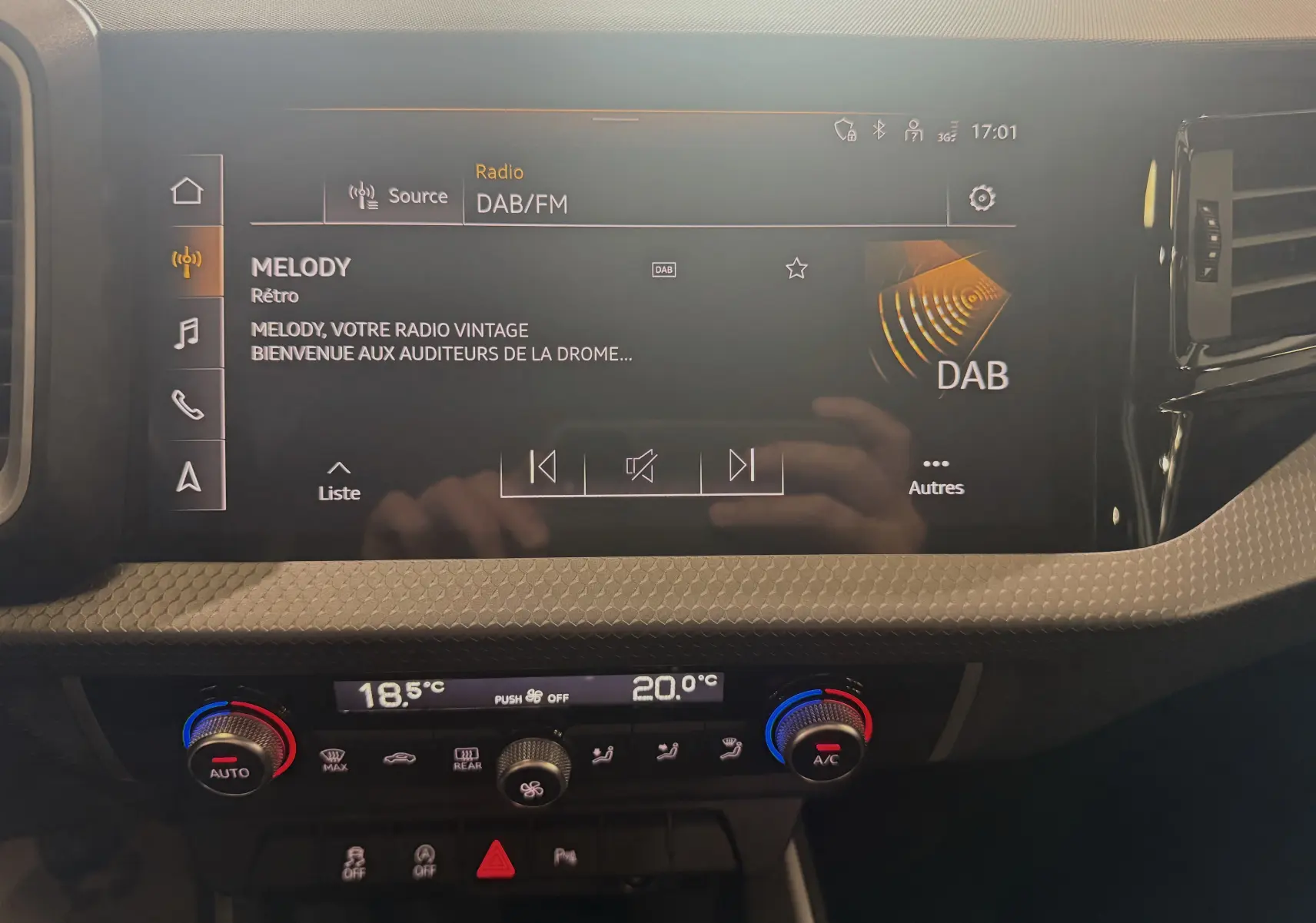 Écran tactile central de l'Audi A1 2024 affichant la radio DAB avec commandes de climatisation digitale en dessous.