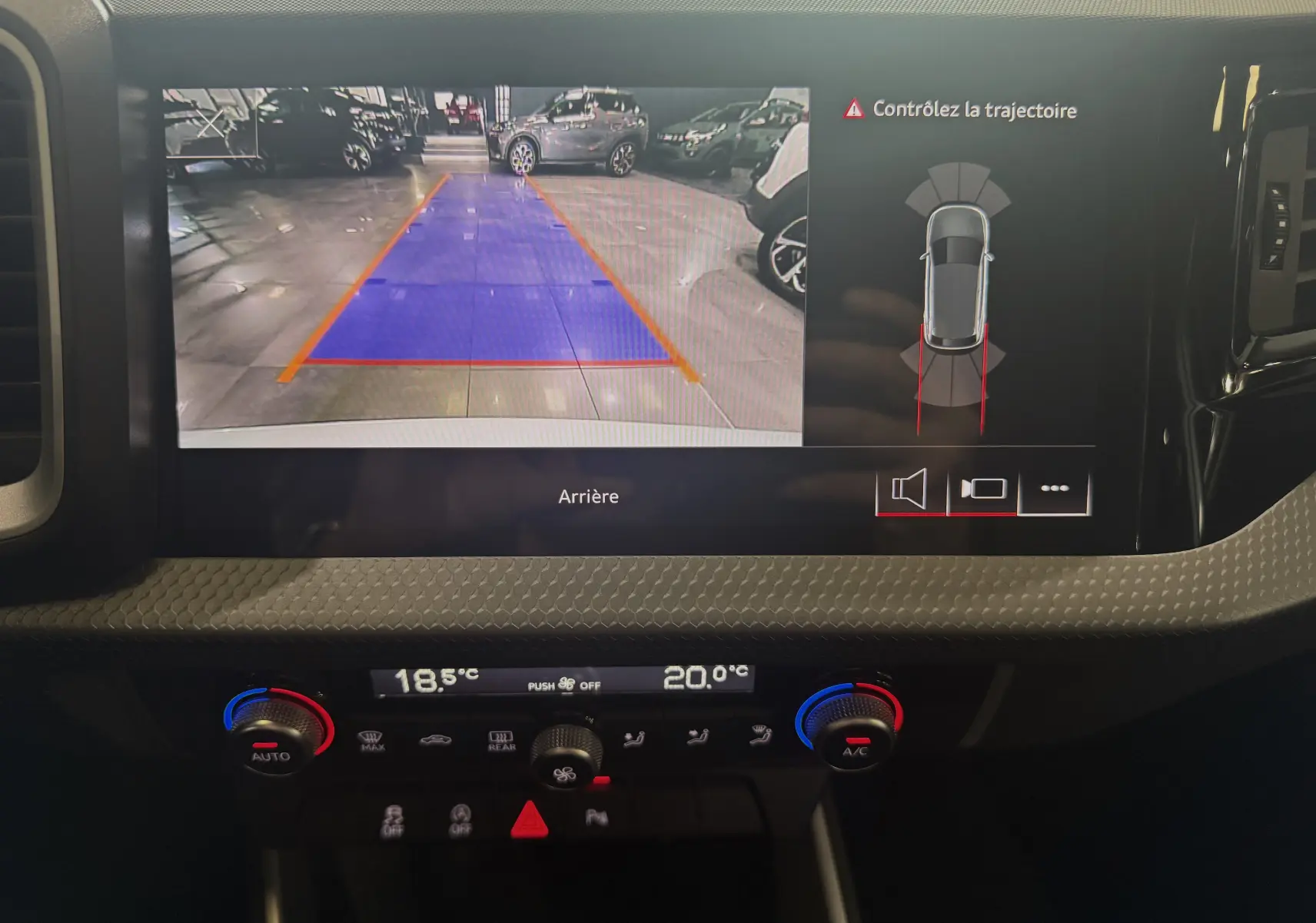 Écran multimédia de l'Audi A1 2024 affichant la caméra de recul avec guidage de trajectoire, tableau de bord noir.